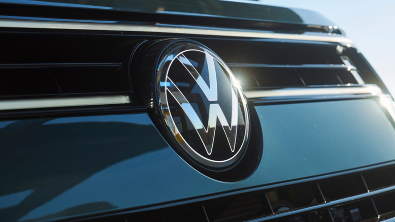 Close up view of the front VW emblem badge on an Atlas shown in Sacramento Green Metallic.