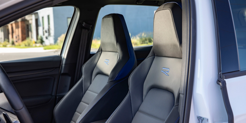 Front sport seats of a Golf R seen through the open driver’s door.