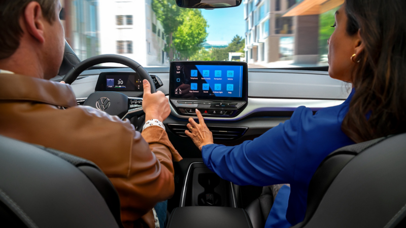 A close-up shot of an ID.4 dashboard, focusing on the passenger reaching out for the available 12” touchscreen display.