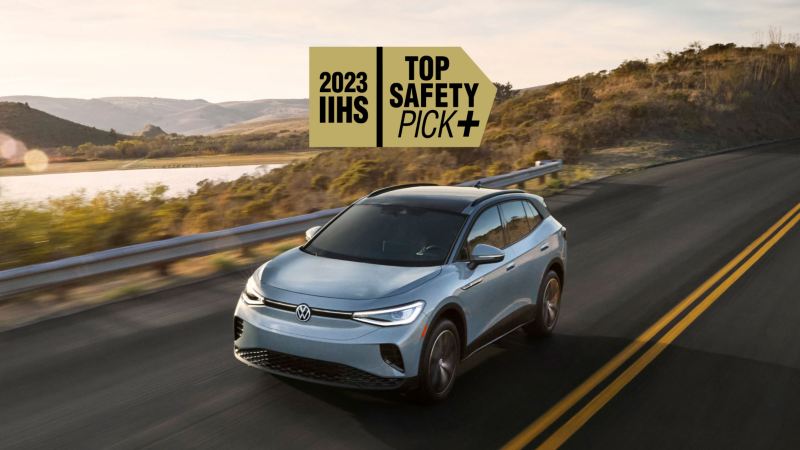 Front view of an ID.4 shown in Arctic Blue Metallic driving with mountains and a lake in the background with a 2023 IIHS TOP SAFETY PICK+ graphic superimposed on image.