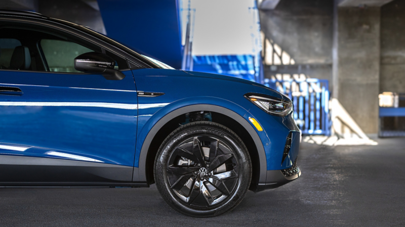 Close-up image of the available 20" black alloy wheels on the ID.4 shown in Mountain Lake Blue Metallic