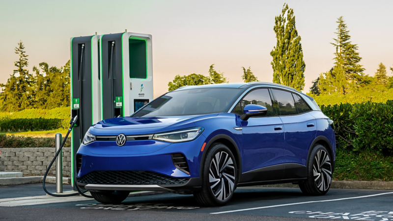 Frontal 3/4 view of a ID.4 shown in Mountain Lake Blue Metallic parked at a charging facility