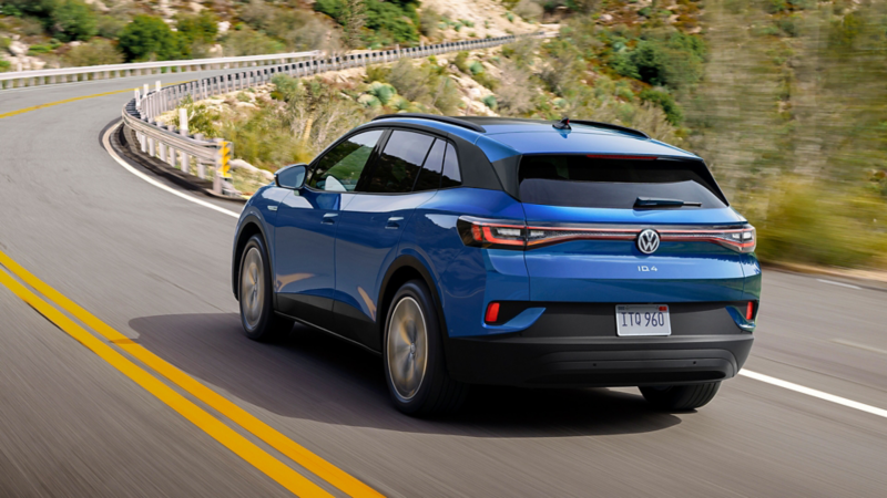 A rear shot of an ID.4 in Mountain Lake Blue Metallic driving up a two-lane mountain road