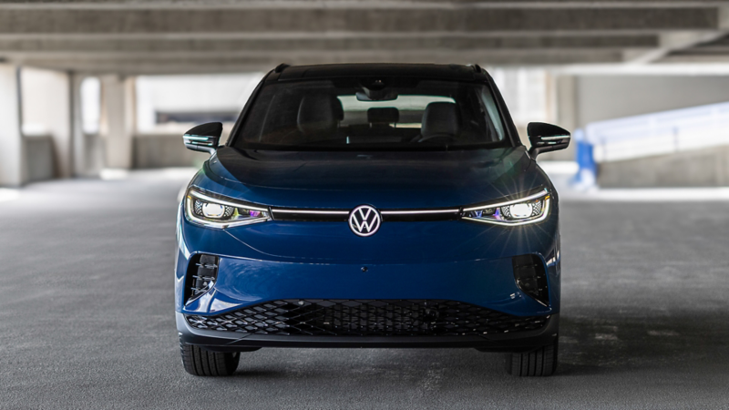 Frontal view of the ID.4 shown in Mountain Lake Blue Metallic parked in a industrial setting