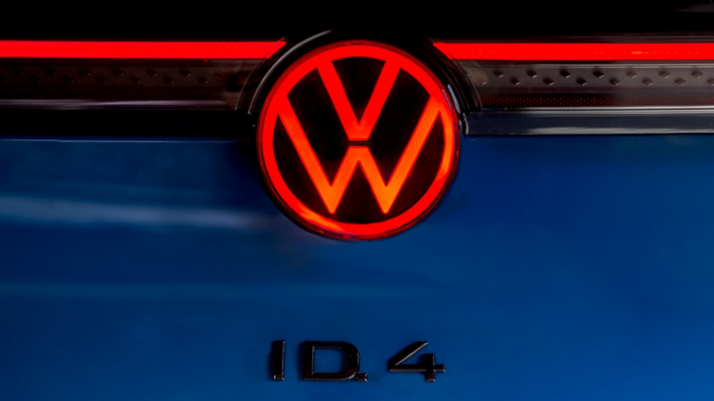 Close up of the illuminated VW logo and available black ID.4 badge on the ID.4 shown in Mountain Lake Blue Metallic