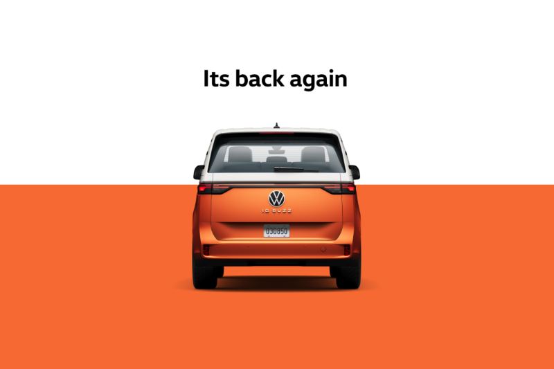 A back view of the ID. Buzz in Energetic Orange in front of a two-tone white and orange background with the words “Its back again” centered above the vehicle.
