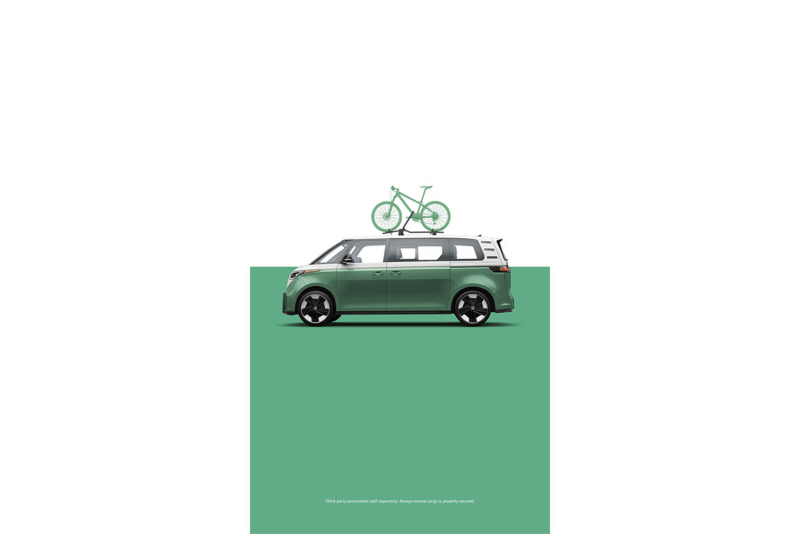 A side view of the ID. Buzz in Mahi Green Metallic with a bike attached to the roof rack in front of a two-tone white and green background. 