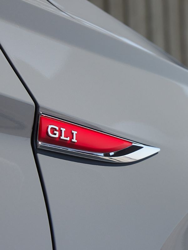 Close-up shot of red GLI badging on passenger side fender of a Jetta GLI shown in Pure Gray.
