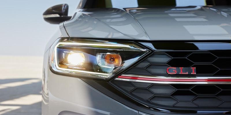 Close up of LED projector headlights with Daytime Running Lights on a Jetta GLI in Pure Gray.