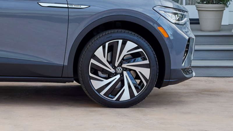 Close-up shot of available 21-inch alloy wheel on a parked ID.4 SUV shown in Pure Gray. 
