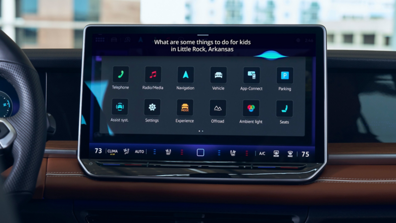 The center touchscreen display in a Tiguan is shown with the text "What are thing to do for kids in Little Rock, Arkansas" on the screen.