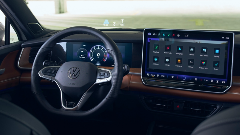 Close up view of driver's side dash in Tiguan with the available head-up display information projected onto the windshield.