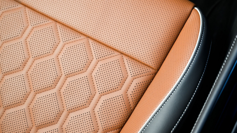 Detalle del patrón de costura en los asientos de un Tiguan con superficies de cuero Amber Brown disponibles.