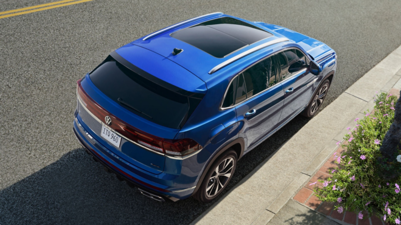 Bird’s-eye rear view of the Atlas Cross Sport in Mountain Lake Blue parked on the side of a street.