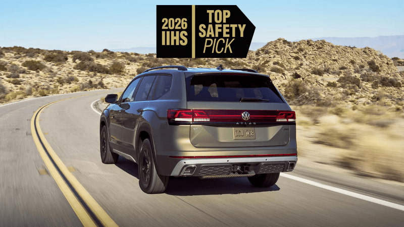 Rear view of an Atlas shown in Avocado Green Metallic driving on a highway through the desert with a safety rating icon overlayed at the top of the image.