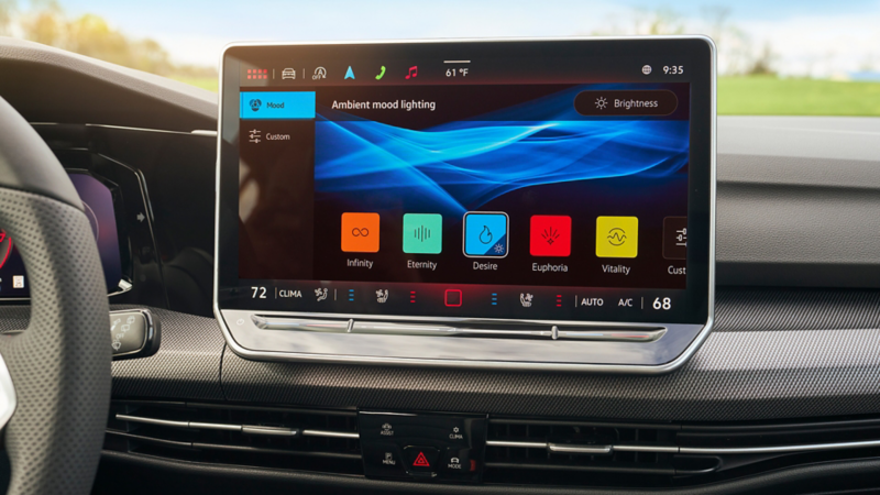 Primer plano de la pantalla táctil en el Golf GTI que muestra la configuración de iluminación ambiental con temas seleccionables que incluyen Infinidad, Eternidad, Deseo, Euforia y Vitalidad.
