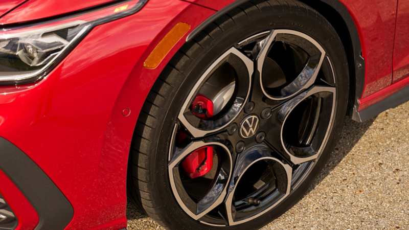 Close up shot of a black and silver alloy wheel on the Kings Red Metallic Golf GTI. 