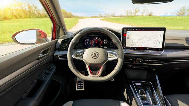 Interior view of the Kings Red Metallic Volkswagen Golf GTI Autobahn focusing on the steering wheel and dashboard interface.