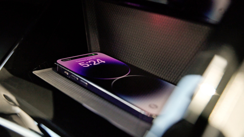 Close up of a mobile device in the wireless charging station of the Golf GTI panel.