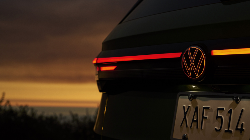 Vista de cerca de las luces traseras LED y el logo de VW iluminado en un Taos.