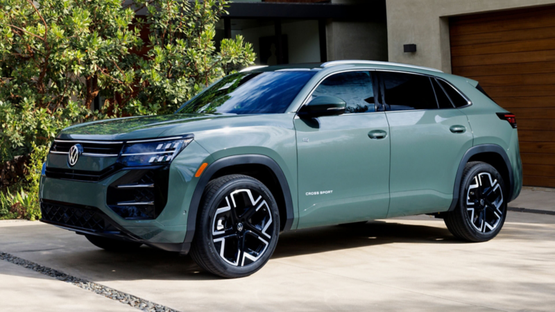 An Atlas Cross Sport shown in Dark Sage Metallic parked in the driveway of an upscale house. 