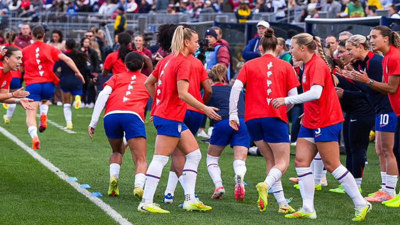 Un equipo de fútbol femenino está reunido en un campo de fútbol de estadio animándose mutuamente y preparándose para un partido.