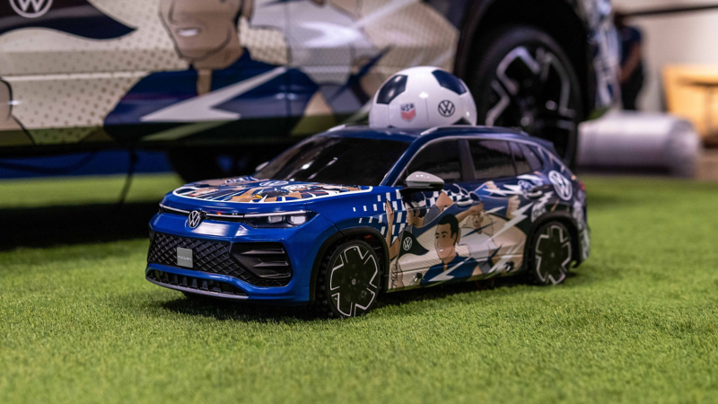 Primer plano de un vehículo de juguete Tiguan en miniatura con control remoto, decorado con un vinilo temático de fútbol y un balón de fútbol colocado en el techo.