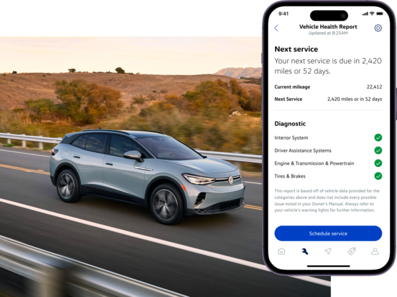 Front view of an ID.4 shown in Arctic Blue Metallic driving with mountains and a lake in the background. The myVW app is displayed on a superimposed mobile phone.