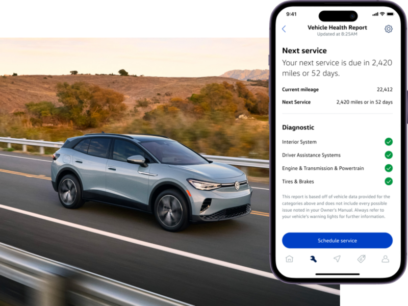 Front view of an ID.4 shown in Arctic Blue Metallic driving with mountains and a lake in the background. The myVW app is displayed on a superimposed mobile phone.