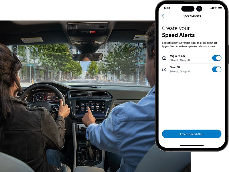 A man and woman sit in their VW with the MyVW app displayed on a superimposed mobile phone.