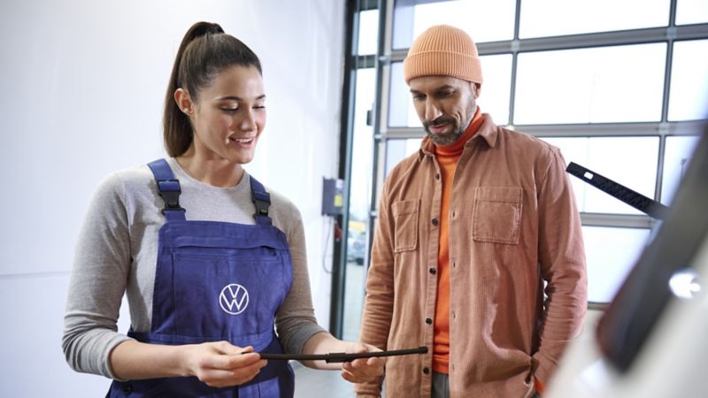 A VW representative showing a woman some information on a piece of paper