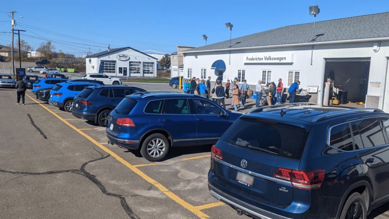 Several blue Volkswagens line a parking lot at Fredericton Volkswagen.