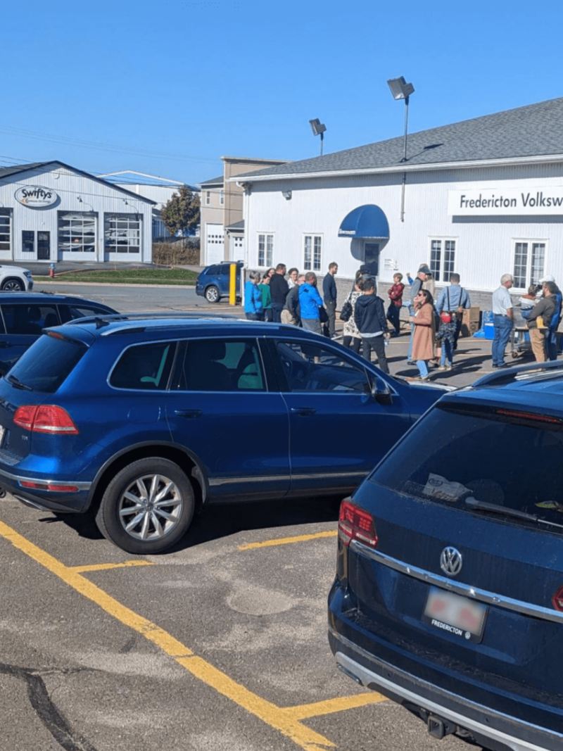 Several blue Volkswagens line a parking lot at Fredericton Volkswagen.