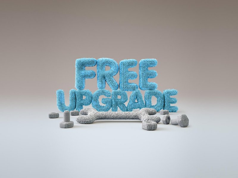 Blue letters spelling "FREE UPGRADE" on a gray background. The 3D letters appear textured, surrounded by scattered tool shapes, conveying improvement