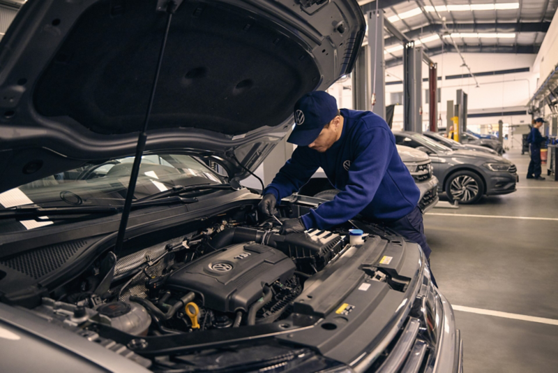 VW service employee holds a bottle of AdBlue® in his hand