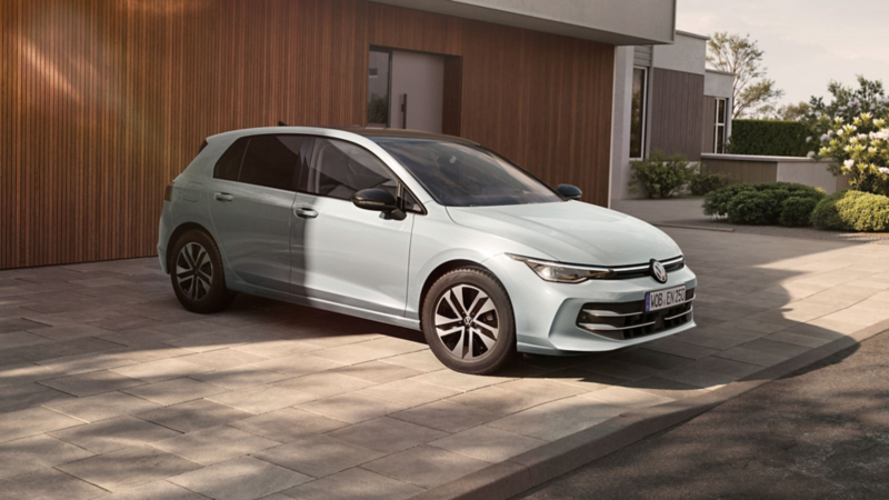 Silberner VW Golf ENERGY vor modernem Haus mit Holzfassade.