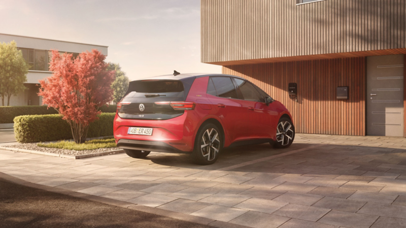 Roter VW ID.3 ENERGY vor modernem Haus mit Holzfassade.