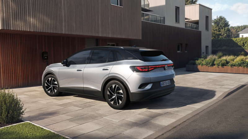 Silberner VW ID.4 ENERGY vor modernem Haus mit Holzfassade