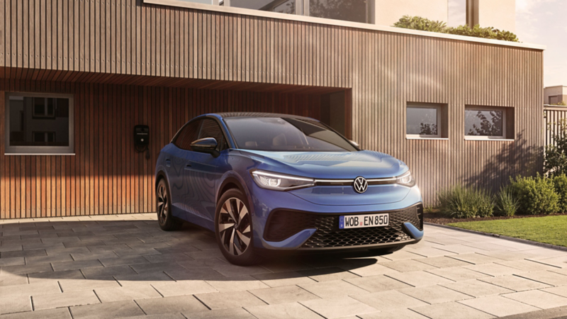 Blauer VW ID.5 ENERGY vor modernem Haus mit Holzfassade.