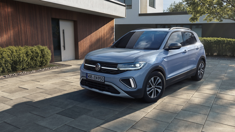 Silberner VW T-Cross ENERGY vor modernem Haus.