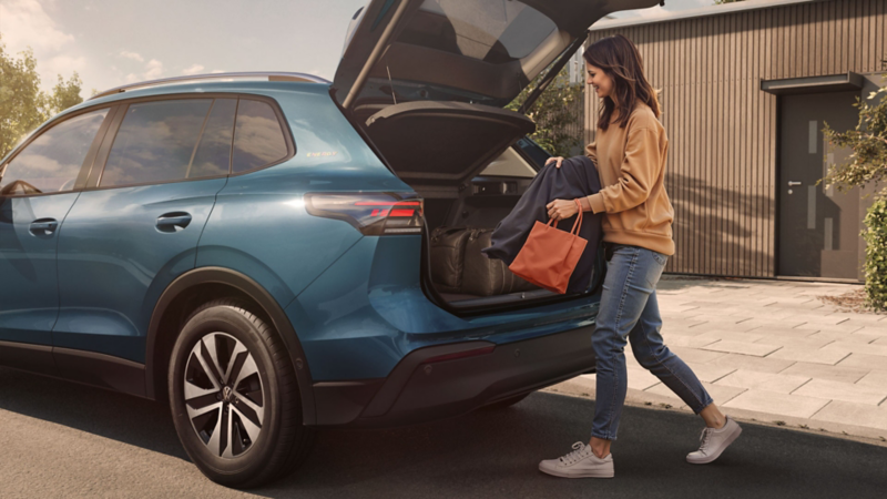 Blauer VW Tiguan ENERGY mit offenem Kofferraum in Wohnstraße.