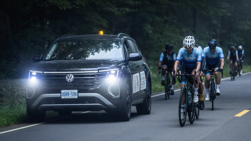 Un Atlas de VW roule à côté d’un groupe de cyclistes.