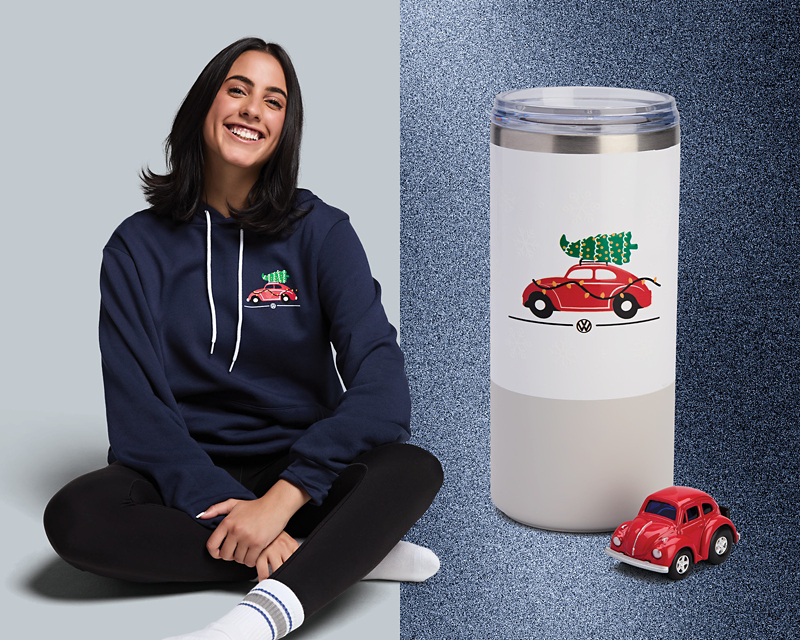 A smiling girl wearing a Beetle hoodie with a thermos.