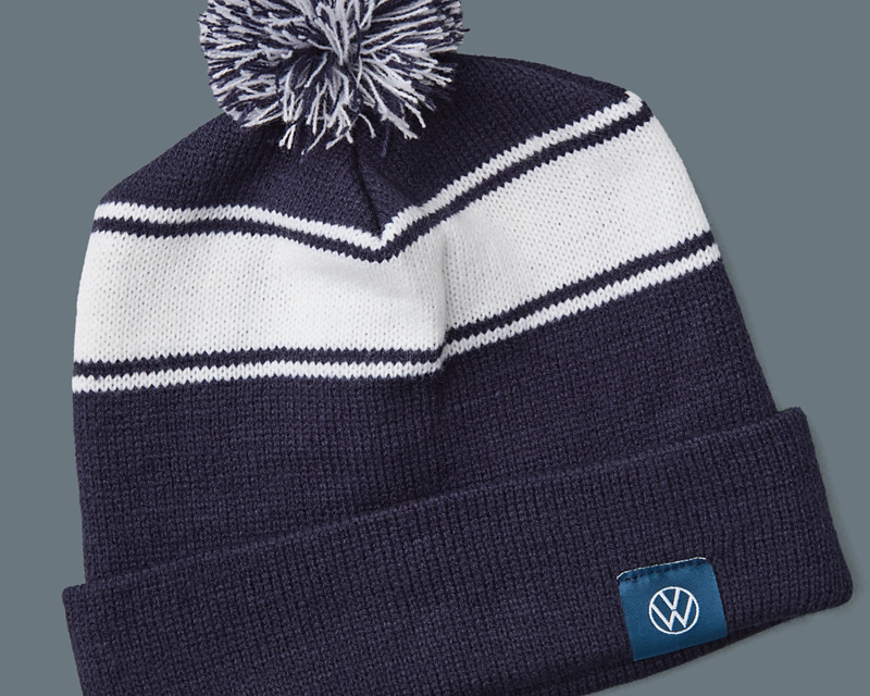 A blue knitted wool hat with a white stripe and a tassel.