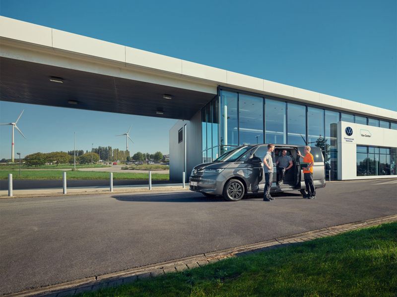 Volkswagen Multivan met geopende deur met 3 medewerkers