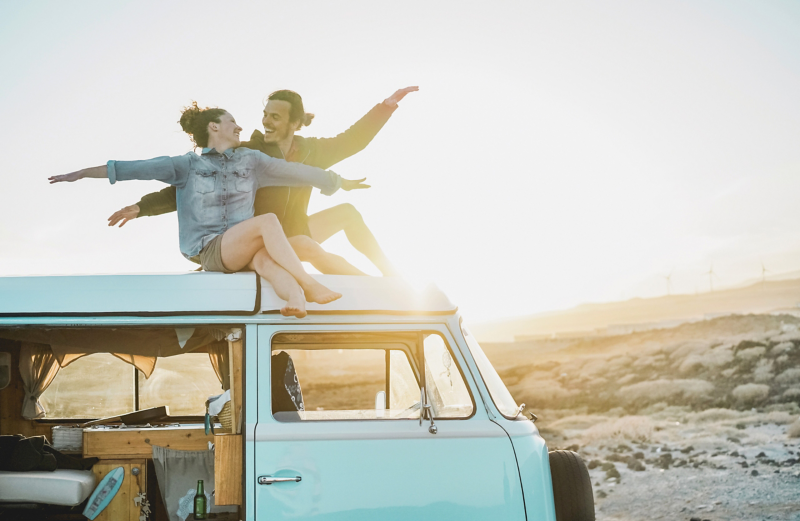 VanLife情境圖 - 情侶坐在Tiffany綠的T2車頂，車側滑門開啟可窺見自行加裝的木製流理台及收納空間