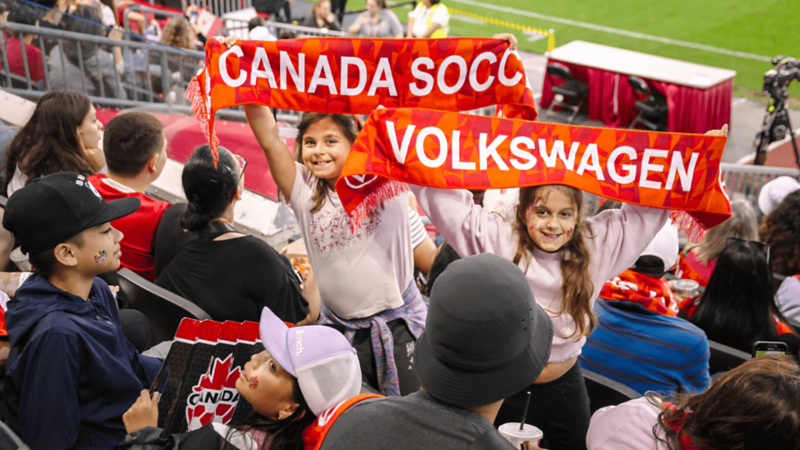 Un collage du jour du match : une famille entre dans le stade, des fans tiennent des foulards Canada et posent devant des arrière-plans VW x Fierté. 