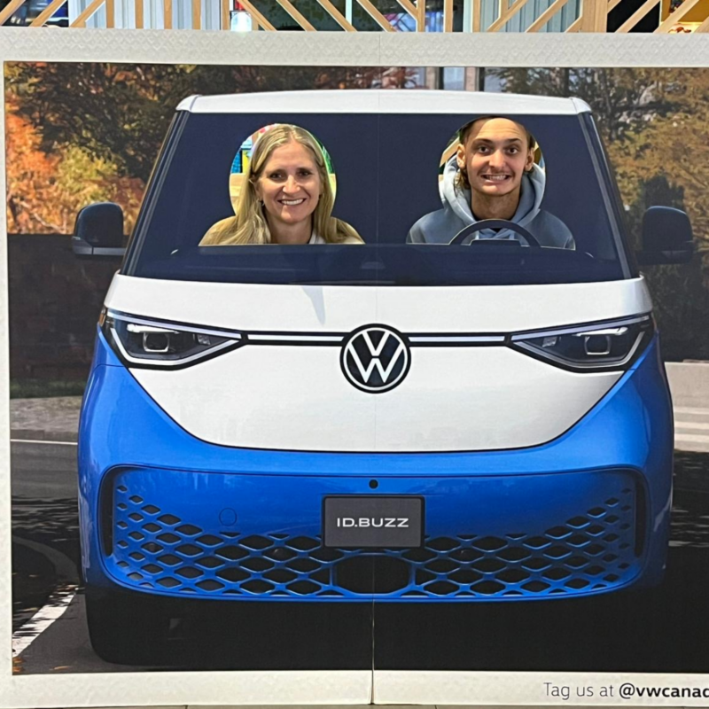 Two people pose with their heads in an ID. Buzz cutout at the movie theatre during the Venom: The Last Dance event. 