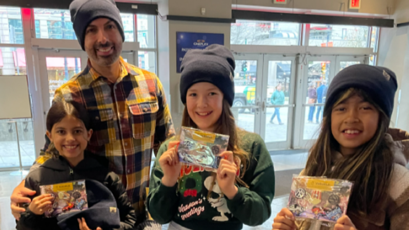 A collage featuring a dad with three kids holding branded cards, a family posing in a VW cutout, and the welcome table. 