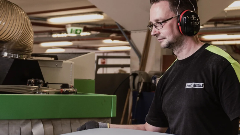 Medewerker van Pon Logistics met gehoorbescherming aan het werk in een werkplaats voor bedrijfswageninrichting.